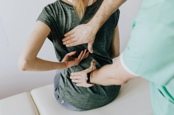 Vrouw met rugklachten bij de kinesist